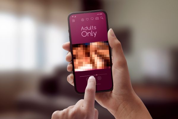 Woman watching porn videos on her smartphone, adults only apps